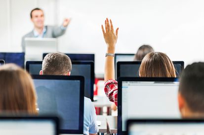 Femme levant la main dans une classe